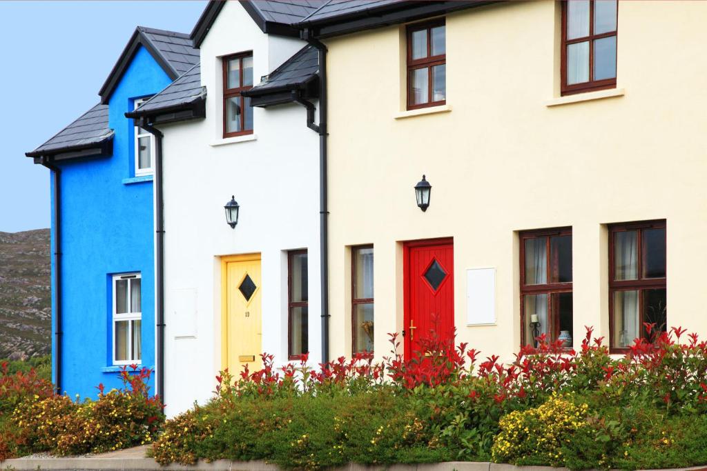 una fila di case colorate con una porta rossa di Ardgroom Leisure Village ad Ardgroom