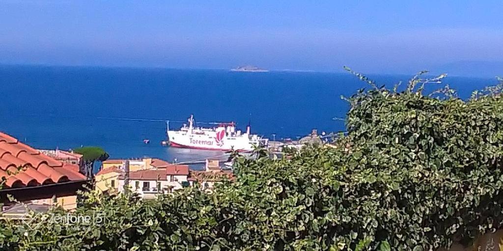 un gran barco en el agua cerca de una ciudad en Villa Isa, en Rio Marina