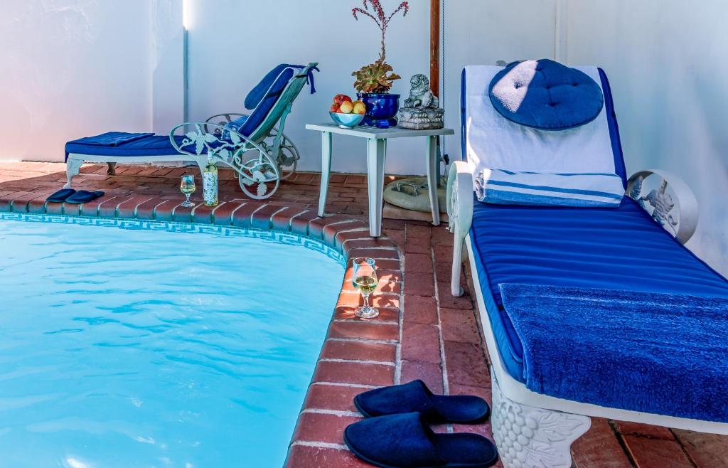 a bedroom with a bed next to a swimming pool at Bleu Cobalt Cottage in Franschhoek