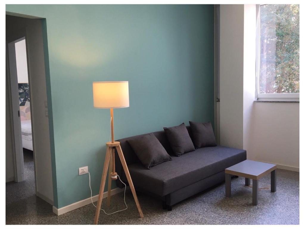 Una sala de estar con un sofá y una lámpara. en elefante appartamenti, en Pescara