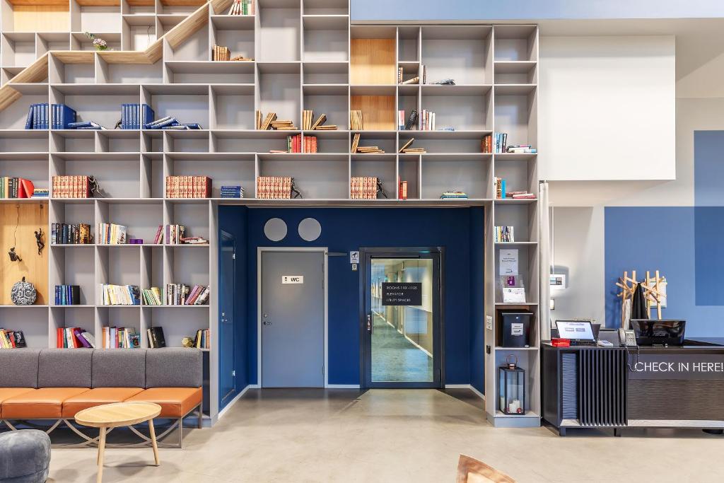 泰比的住宿－Part-Time Home Täby，图书馆拥有蓝色的墙壁和书架