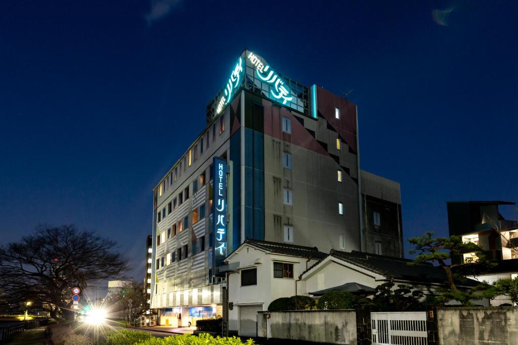 a tall building with a sign on top of it at Hotel Liberty Kochi (Adult Only) in Kochi