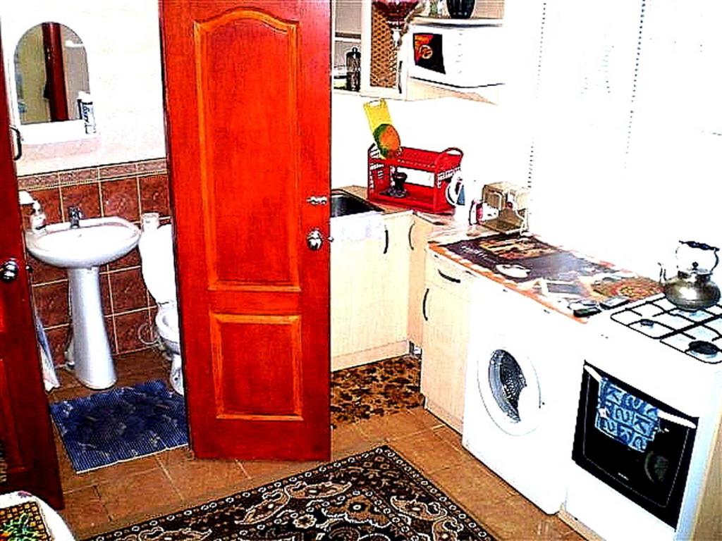 a kitchen with a sink and a red door at 2 ком кв Соборная-Макарова-МАКДОНАЛЬДС 3 кровати Wi-Fi 1этаж отдельный вход in Mykolaiv