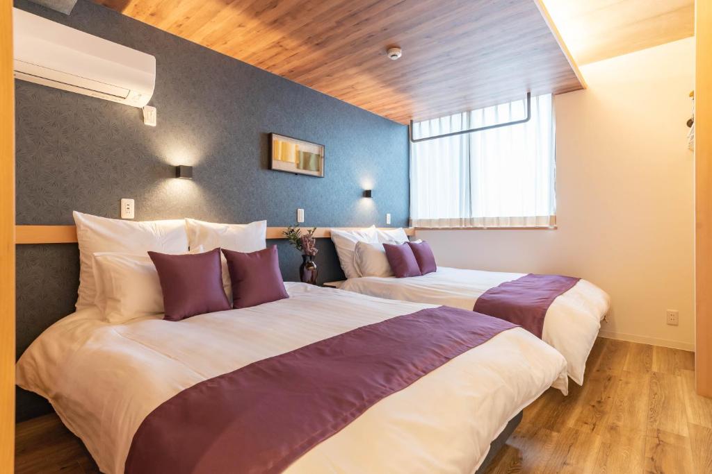 大阪市にあるアッラスクーデリア　ビジュースイーツのホテルルーム 紫色の枕付きベッド2台付