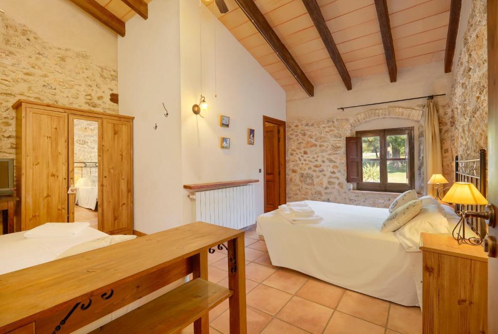a bedroom with a bed and a desk in a room at Turisme Rural Mas Ramades in L'Estartit