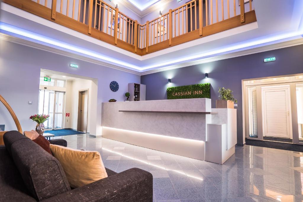 a lobby with purple walls and a reception desk at Cassian Inn in Partizánske