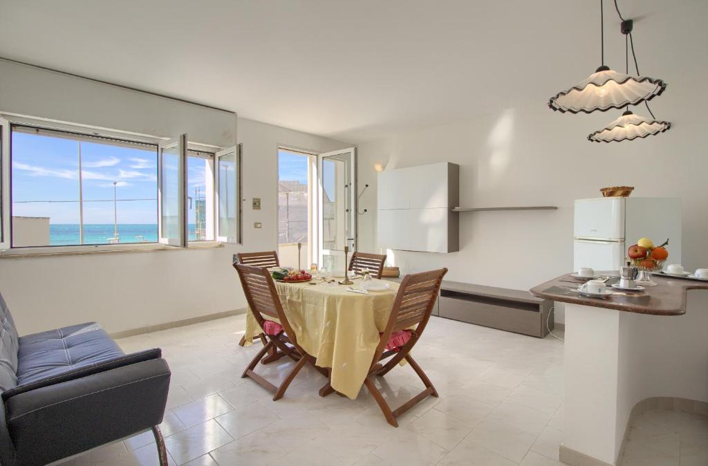 una cucina e una sala da pranzo con tavolo e sedie di Front Beach Torre Mozza a Torre Mozza