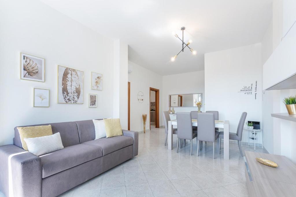 a living room with a couch and a dining room at Luminoso Appartamento con Terrazzo Vicino all'Universita' in Ferrara