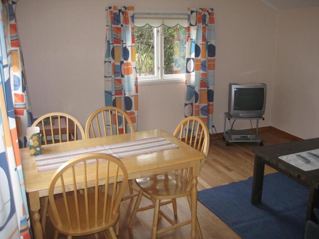 a dining room with a table and chairs and a television at När GK in Stånga