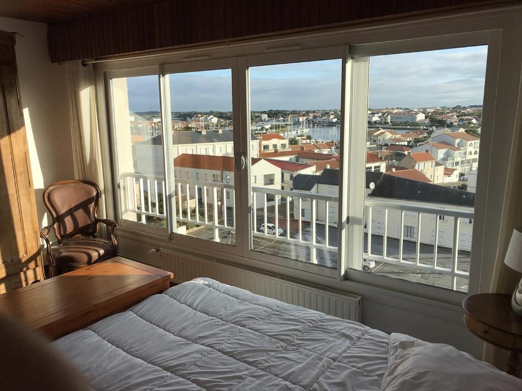 ein Schlafzimmer mit einem Bett und einem großen Fenster in der Unterkunft Résidence Les Pierrettes in Saint-Gilles-Croix-de-Vie