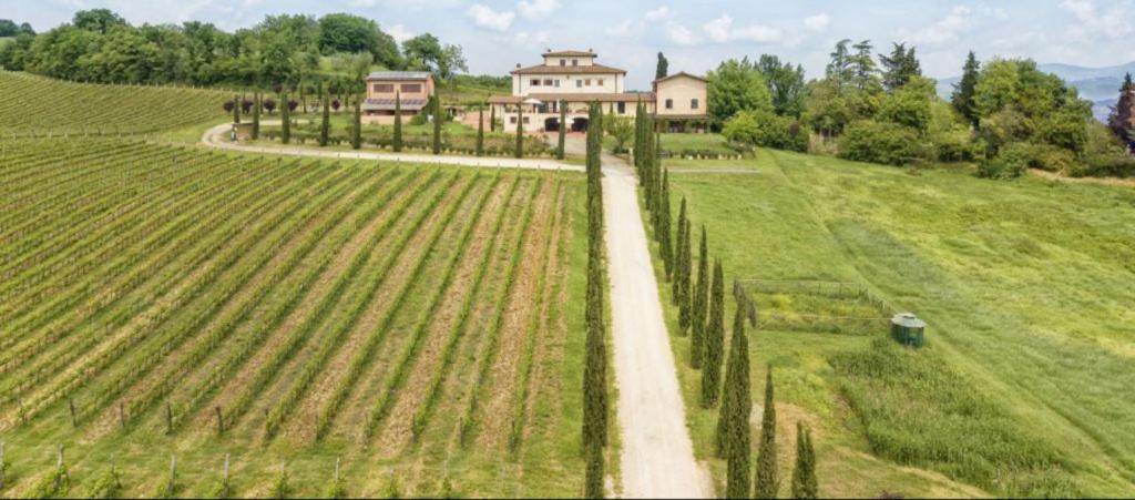 an aerial view of a farm with a house in the background at Fattoria Casagrande in Rignano sullʼArno