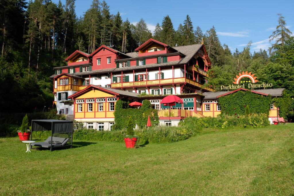 un grand bâtiment au milieu d'un champ dans l'établissement Parkhotel Sole Paradiso, à San Candido