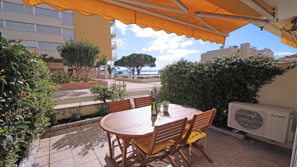 - une table et des chaises sur une terrasse avec un parasol dans l'établissement Palais de la Mer, à Sainte-Maxime