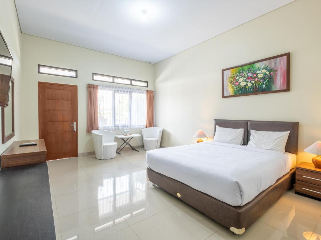 a bedroom with a large bed and a desk at Hotel Parahyangan in Tasikmalaya