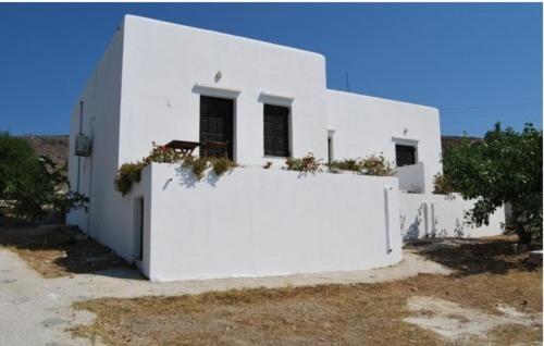 a white house with plants on the side of it at Eleni's Studios in Karavostasi