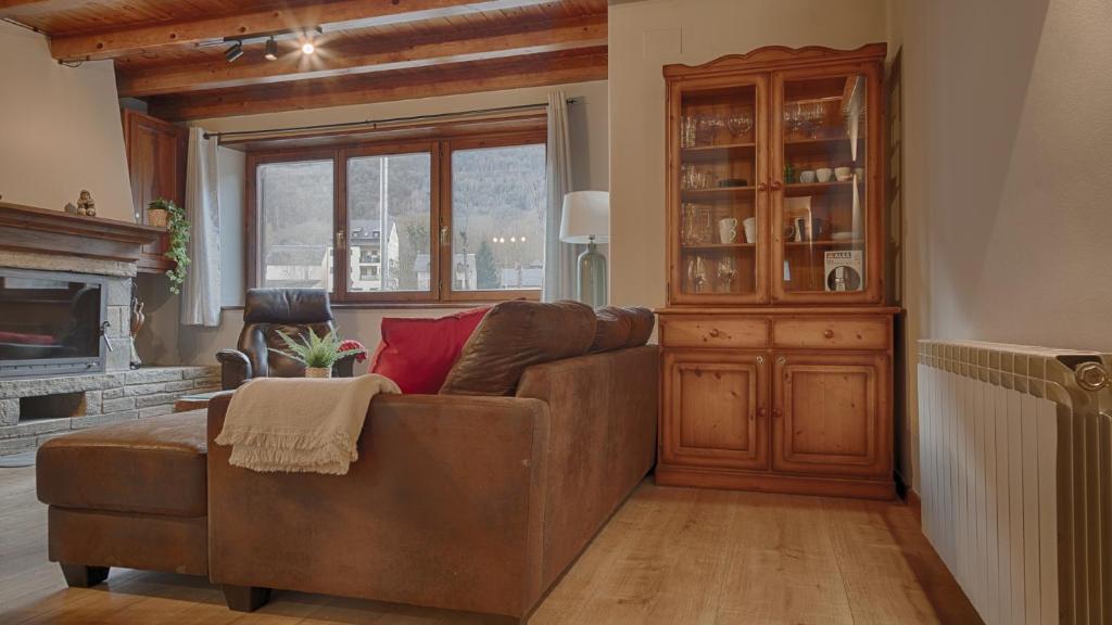 sala de estar con sofá marrón y chimenea en Saplan Real Estate PORTET, en Les