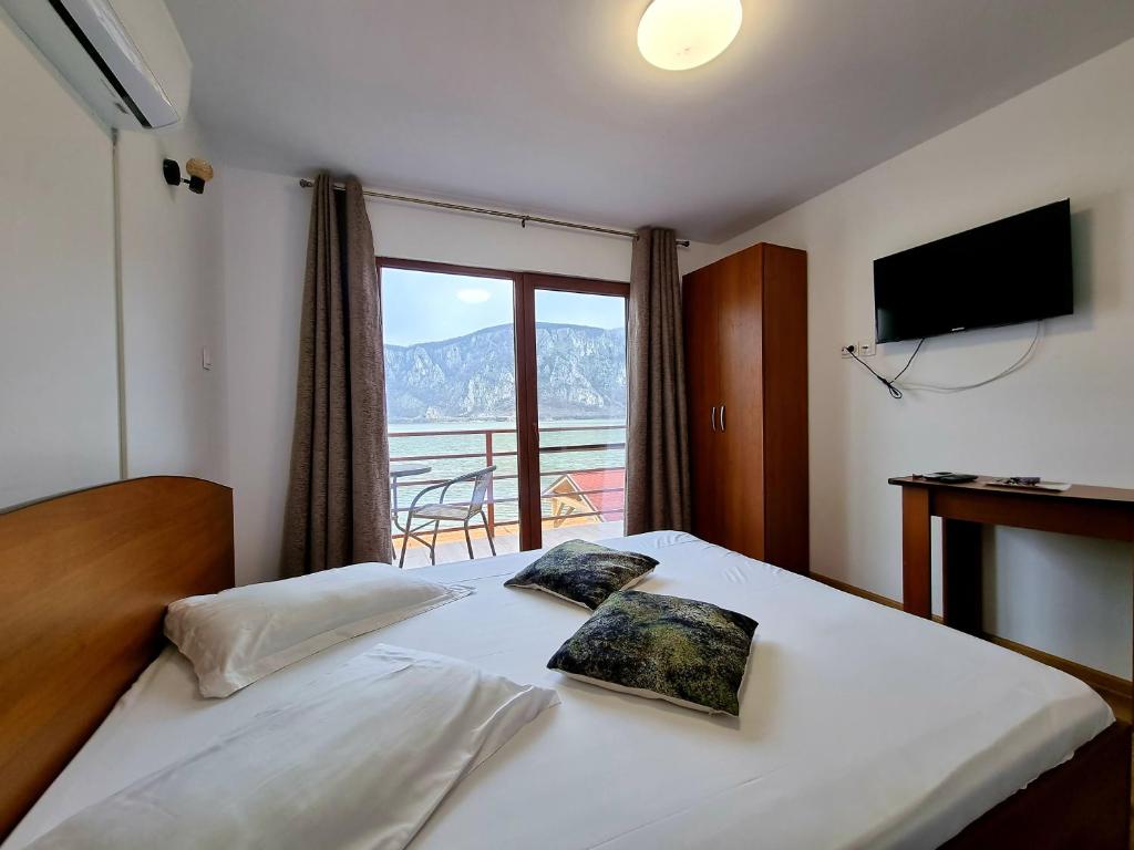 ein Schlafzimmer mit einem Bett und Blick auf einen Balkon in der Unterkunft Escape in Dubova