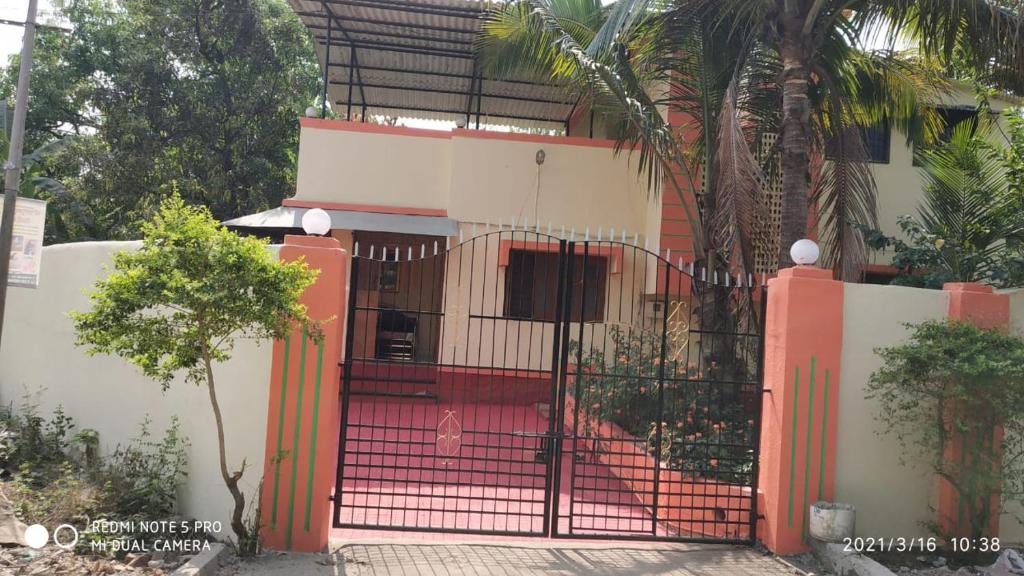 un portail rouge devant une maison dans l'établissement HemHarsh Holiday Home, à Karjat
