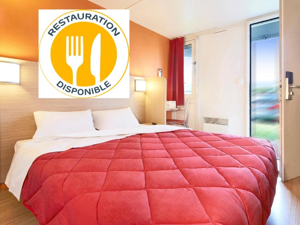 a hotel room with a red bed with a restaurant sign at Premiere Classe Lille Sud - Seclin in Seclin