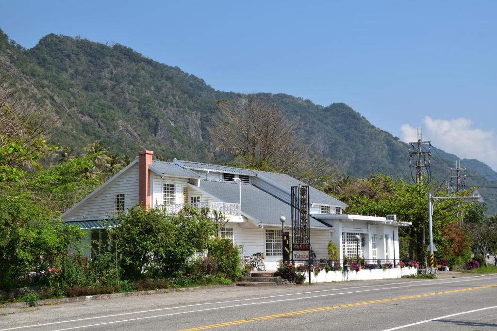 una casa bianca sul ciglio di una strada di Taitung Linyuan B&B a Donghe