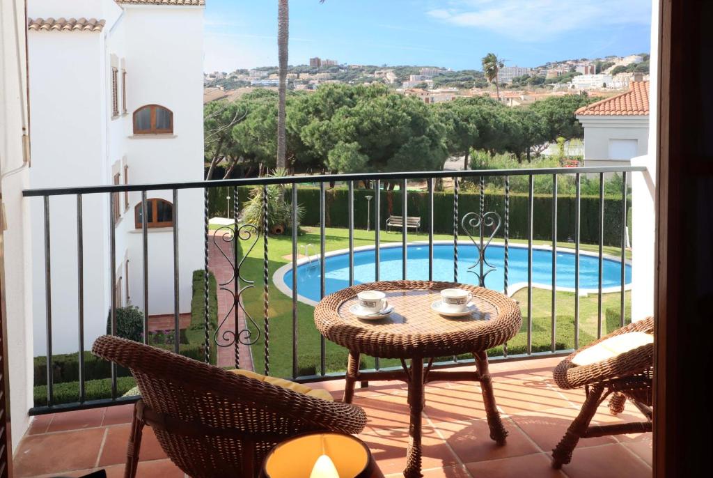 a balcony with a table and chairs and a pool at Jardins de S'agaro per 6 pax, piscina comunitaria y parking E32235 in S'agaro