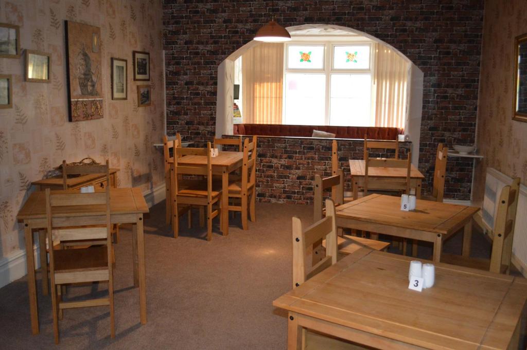 a restaurant with wooden tables and chairs and a window at The Rutlands in Blackpool
