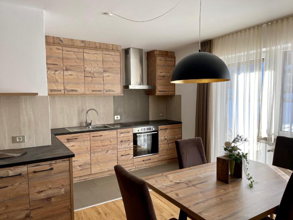 a kitchen with wooden cabinets and a wooden table at Plankensteiner Tschurtschenthaler in Dobbiaco