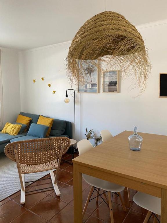 a living room with a table and a couch at Casa São Francisco in Porto Covo