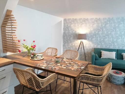 a dining room with a table with chairs and a couch at LE TROPICOCO - hyper centre d'Auray - in Auray