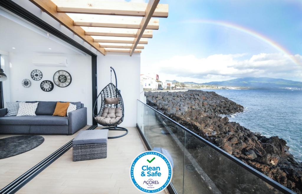 Home at Azores - Oasis House في ساو روكي: غرفة معيشة مطلة على المحيط وقوس قزاز