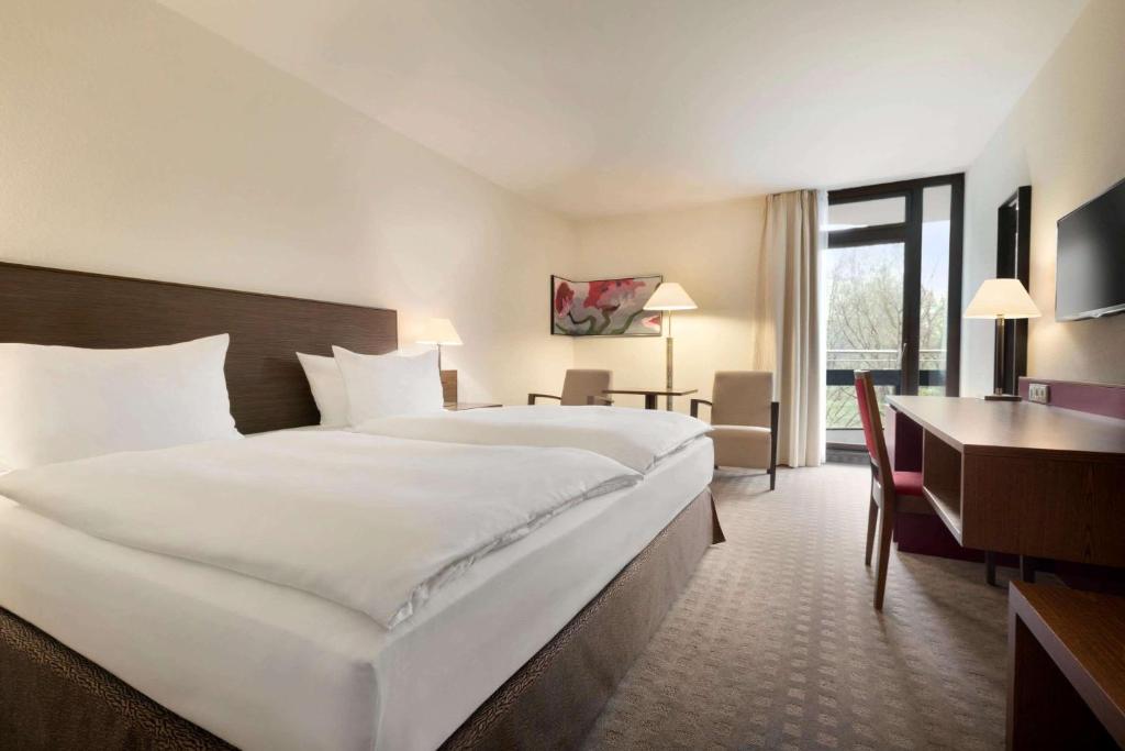 Postel nebo postele na pokoji v ubytování Ramada Nürnberg Parkhotel