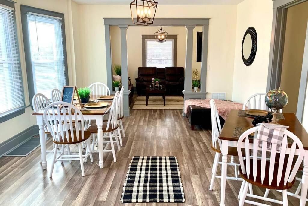 a living room with a dining room table and chairs at The Hennepin House- With Private Yard & Parking, Minutes From Falls & Casino by Niagara Hospitality in Niagara Falls