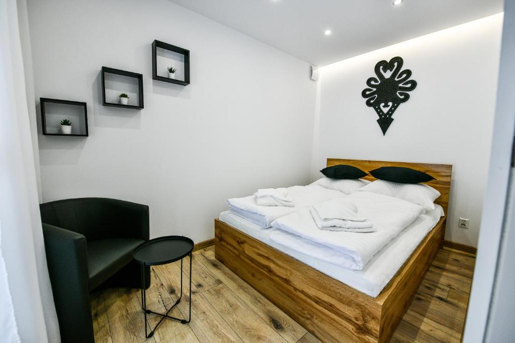 a small bedroom with a bed and a chair at RentPlanet - Apartamenty Bulwary Słowackiego in Zakopane
