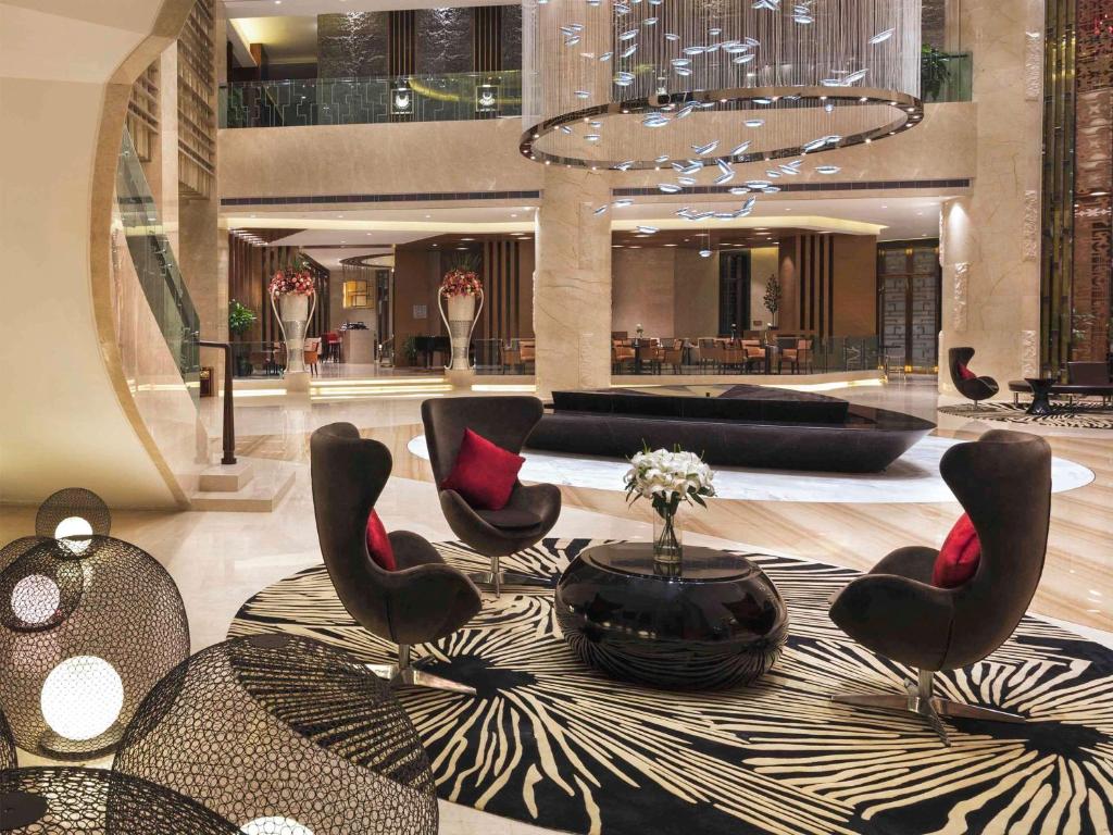 un vestíbulo con sillas y una mesa en un edificio en Movenpick Hotel Enshi, en Enshi