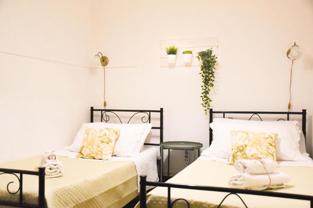 dwa łóżka siedzące obok siebie w pokoju w obiekcie Casa Jolanda B&B w mieście Palermo