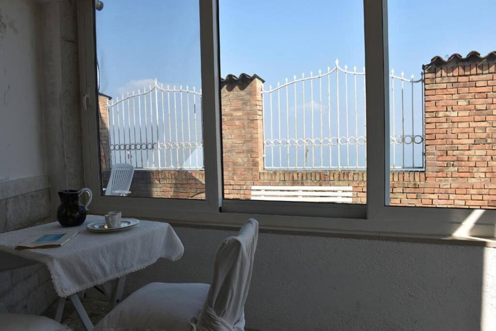 穆拉諾的住宿－L' incantevole paesaggio della laguna di Murano，一个带两扇窗户的房间,配有一张桌子和椅子
