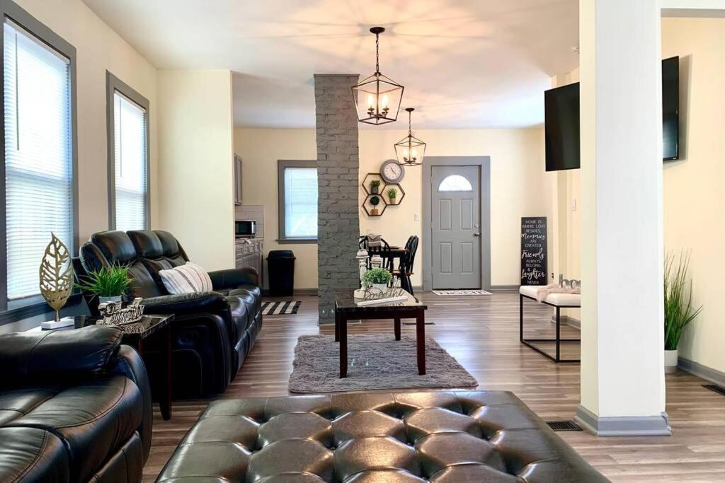 a living room with couches and a table at The Southside Villa- With Private Yard & Free Parking, Minutes From Falls & Casino by Niagara Hospitality in Niagara Falls