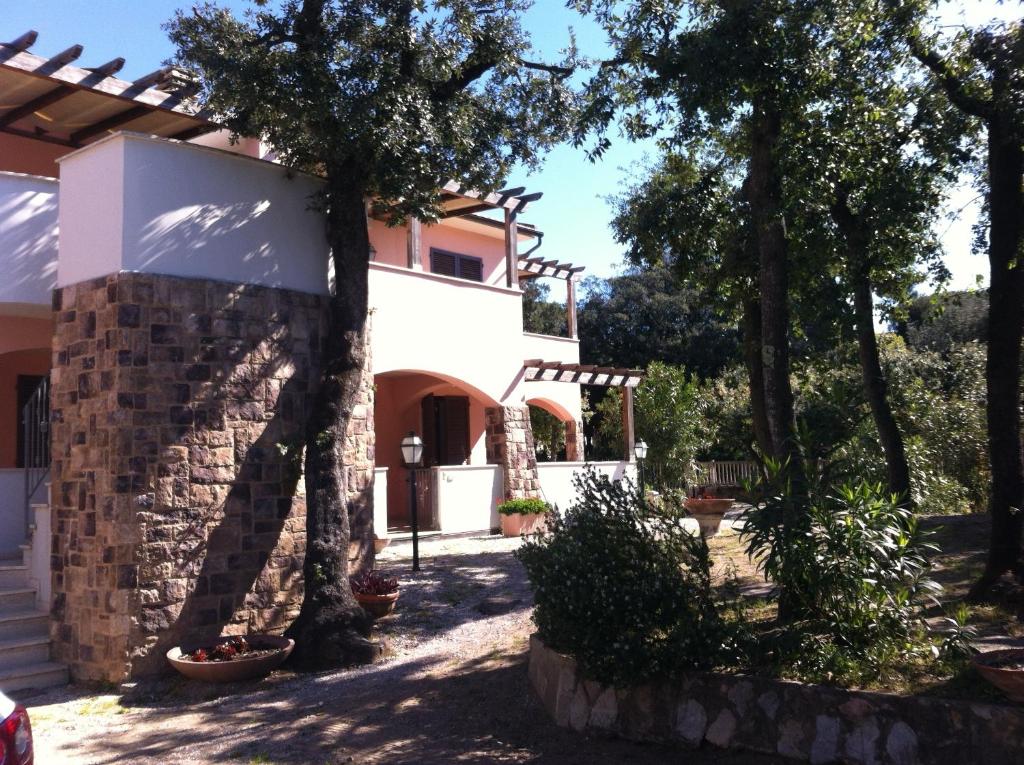 una casa con degli alberi di fronte di Residence Villa Hedy a San Vincenzo