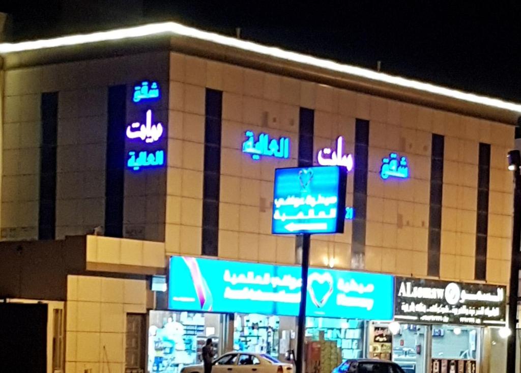 a building with neon signs on the side of it at شقق بيات العالية وادي بن هشبل Bayat Al aliah Apartments in Wadi bin Hashbal in Bin Hashbal