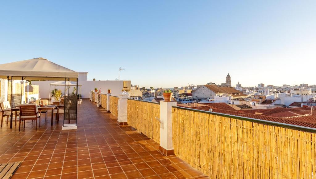 a balcony with a table and chairs on a roof at HOMEABOUT LA MERCED Studios in Málaga