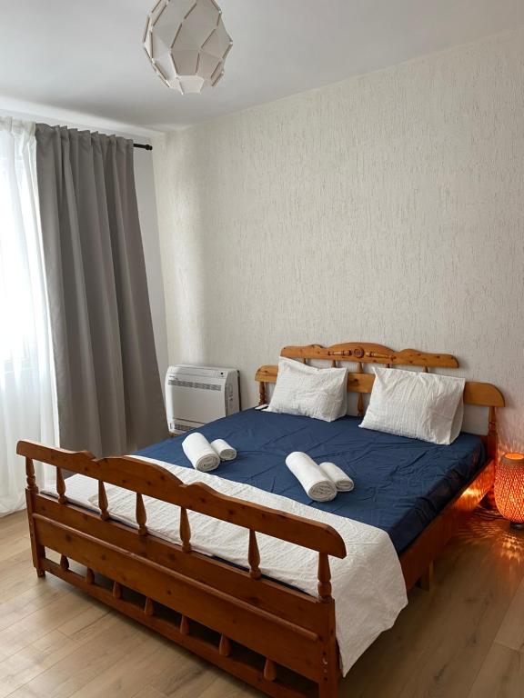 Un dormitorio con una gran cama de madera con almohadas en Apartment Kirili and Metodi 41-8 en Berkovitsa