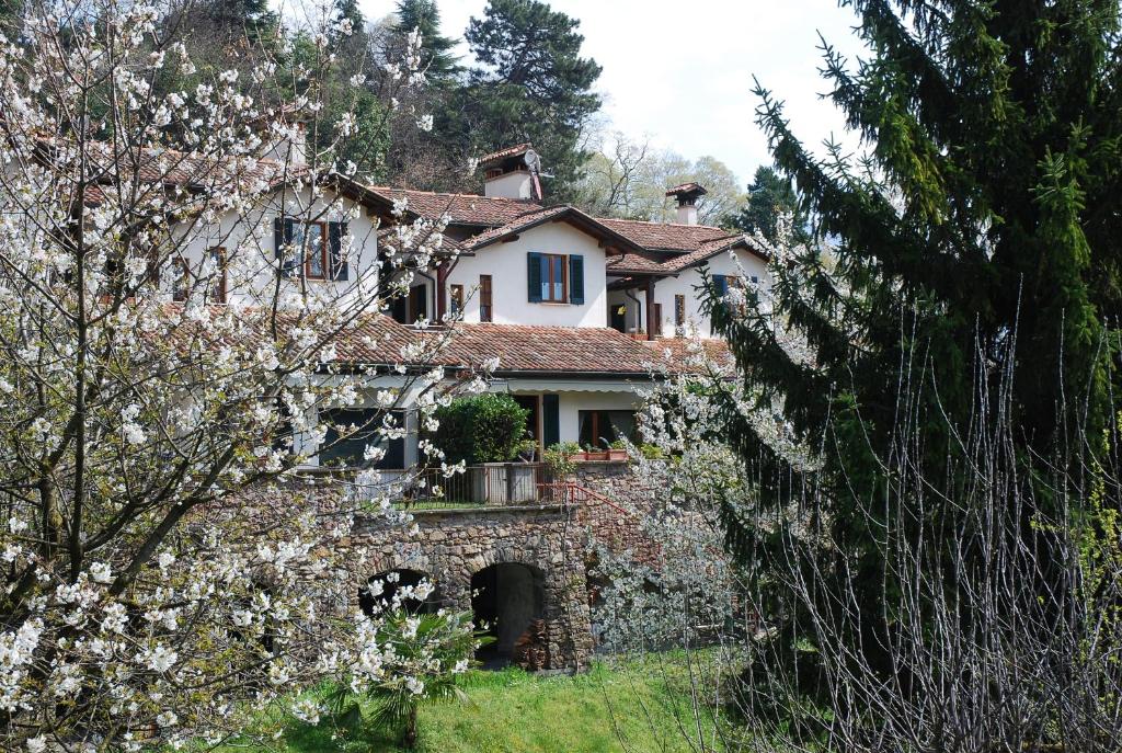 an old house on a hill with white flowers at B&B Selve di Rogaro in Tremezzo