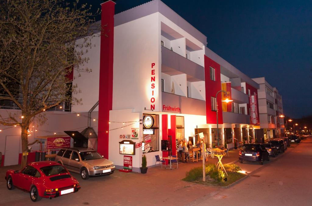 a building with cars parked outside of it at night at Pension Frühwirth in Bad Tatzmannsdorf