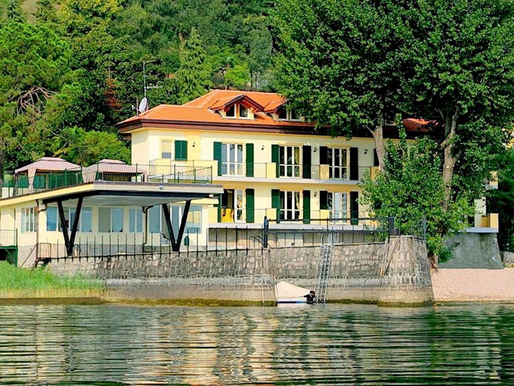 duży dom z łodzią w wodzie w obiekcie Residence located on the shores of Lake Maggiore w mieście Meina