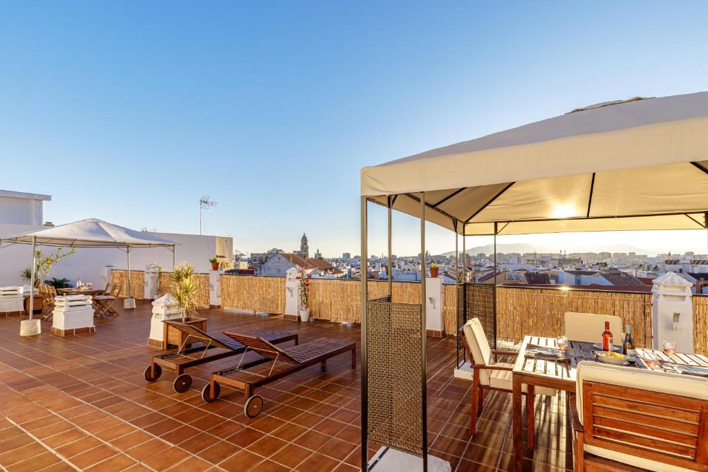 馬拉加的住宿－HOMEABOUT LA MERCED Apartments，屋顶上带桌子和遮阳伞的天井