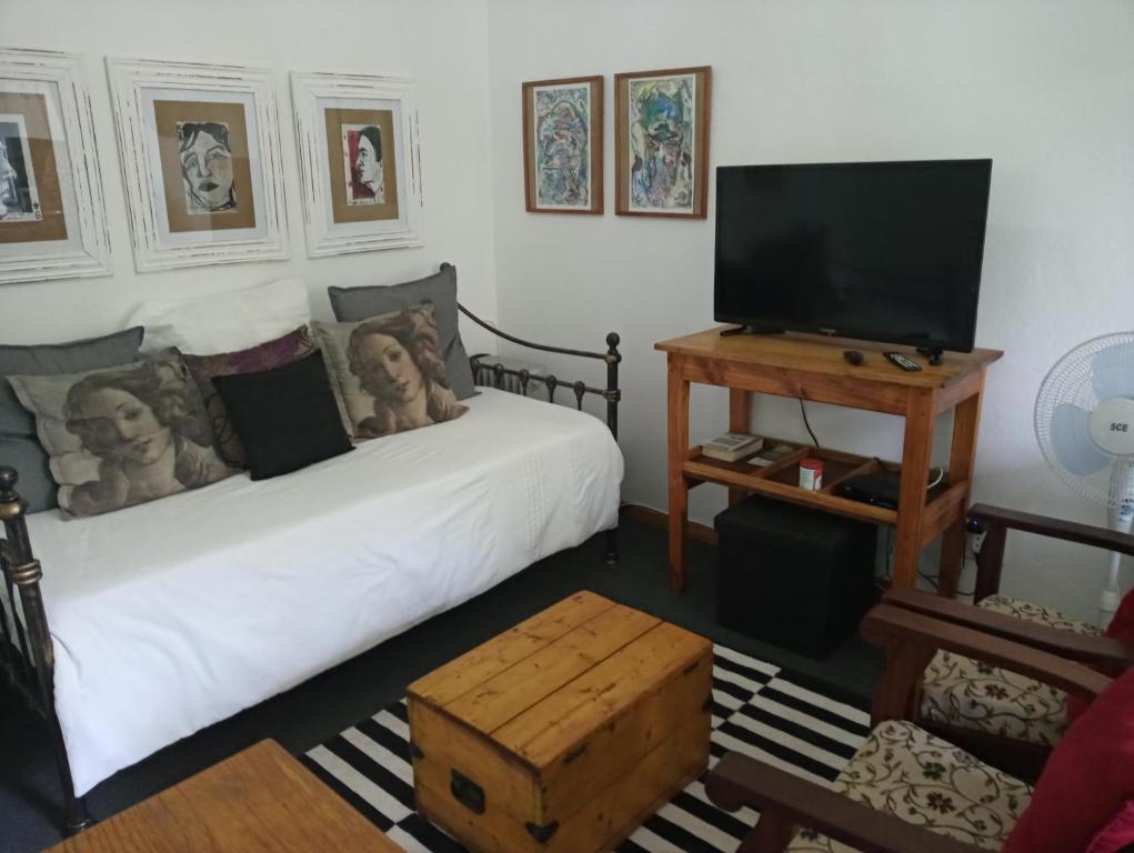 a living room with two beds and a flat screen tv at Grace in Pretoria
