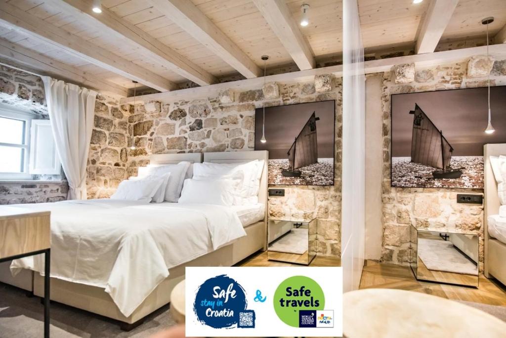 a bed in a room with a stone wall at Villa 5db in Dubrovnik