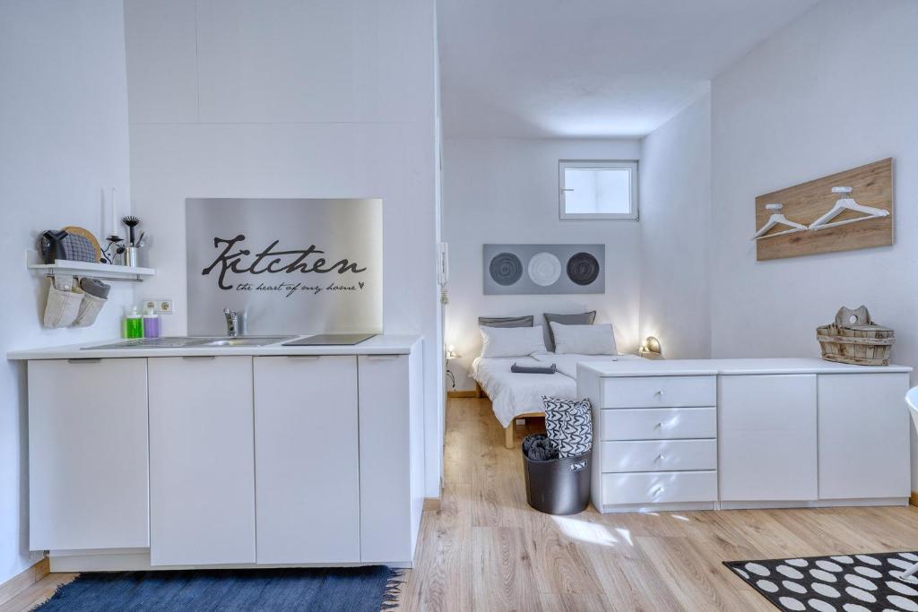Biały pokój z umywalką i łóżkiem w obiekcie Zentral gelegenes Apartment mit Garage und Garten w mieście Caldaro