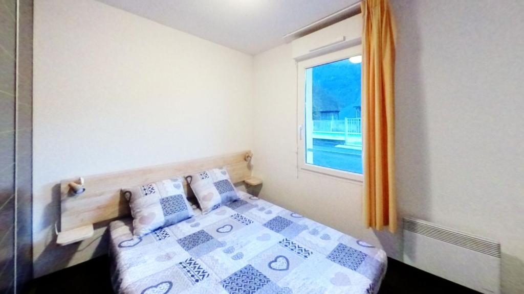 a small bedroom with a bed and a window at Appartement 6 places au cœur de Luz Saint sauveur in Luz-Saint-Sauveur