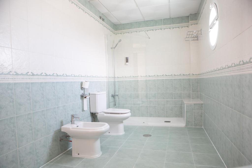 
a white toilet sitting in a bathroom next to a sink at Hotel Blanca Brisa Cabo de Gata in El Cabo de Gata

